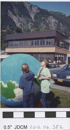 Children with a large model of the earth, outside