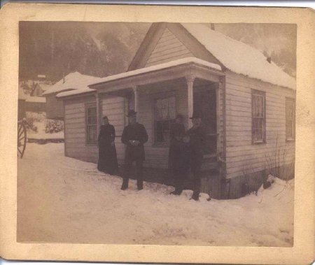 Four people in front of house