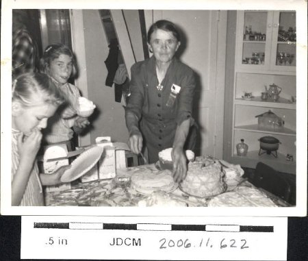 Irma Olson cuts cake