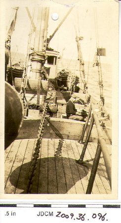 Man sitting on deck of ship